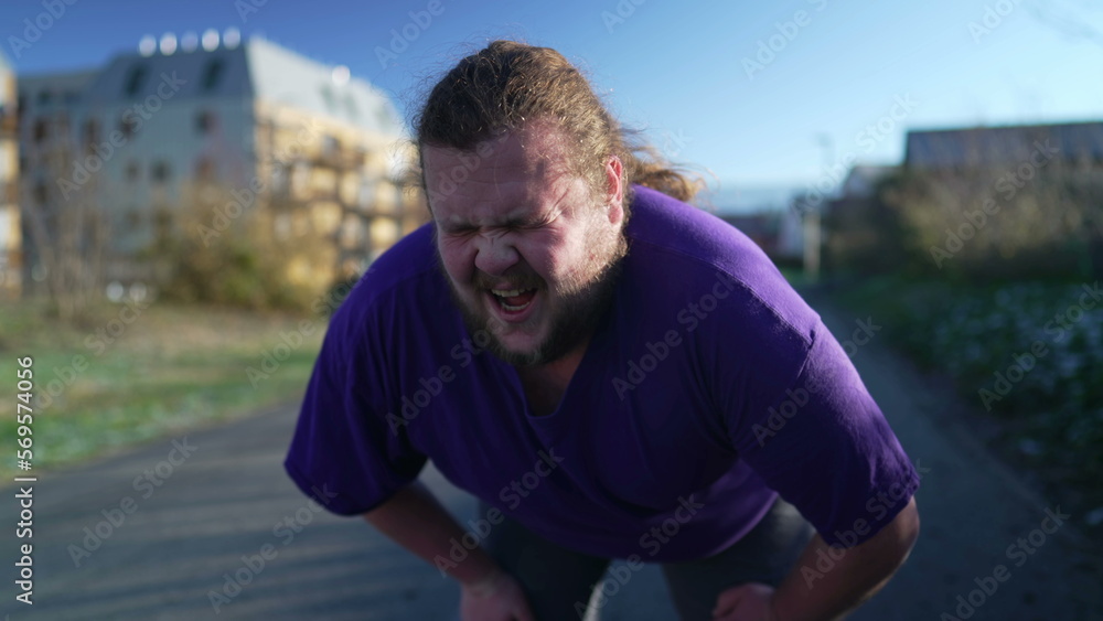 A fat young man taking a break from run. One overweight person recovering from exercising outdoors. Motivational discpline back into shape concept. Guy resting A fat young man taking a break from run. One overweight person recovering from exercising outdoors. Motivational discpline back into shape concept. Guy resting