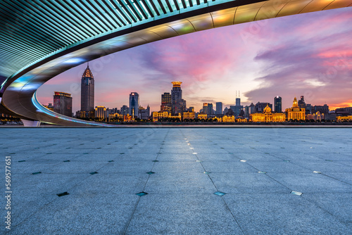 Empty square floors and bridge with city skyline at sunset in Shanghai, China.