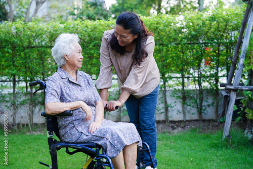 Caregiver help Asian elderly woman disability patient in nursing hospital, medical concept. © manassanant