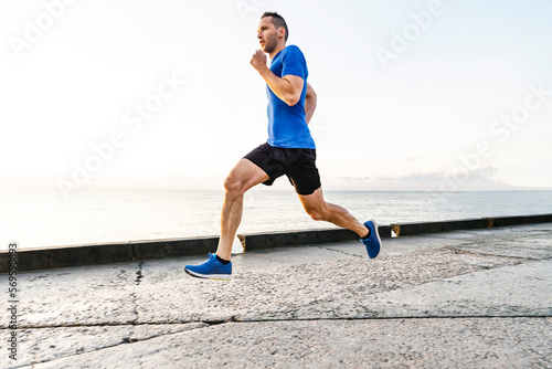 middle-aged male runner run on embankment