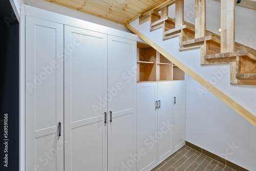 The remaining space under the stairs leading to the basement was made into a storage cabinet