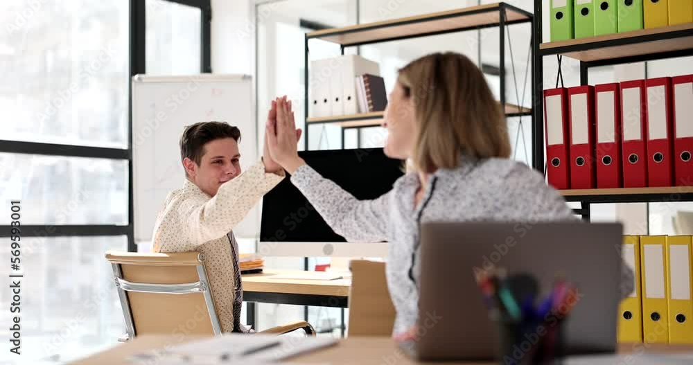 Successful business partners high five in office Successful business partners high five in office