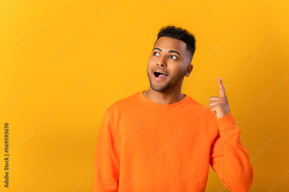 Indian guy has a good idea. Excited happy man point index finger up in sign of new idea or solution standing isolated on yellow background Indian guy has a good idea. Excited happy man point index finger up in sign of new idea or solution standing isolated on yellow background
