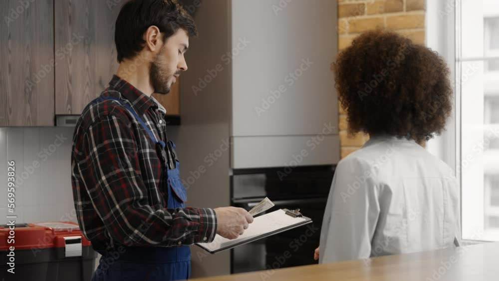 African American woman paying cash for plumbing services to experienced plumber African American woman paying cash for plumbing services to experienced plumber