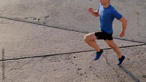 slow motion man athlete running on road in light of sunrise
