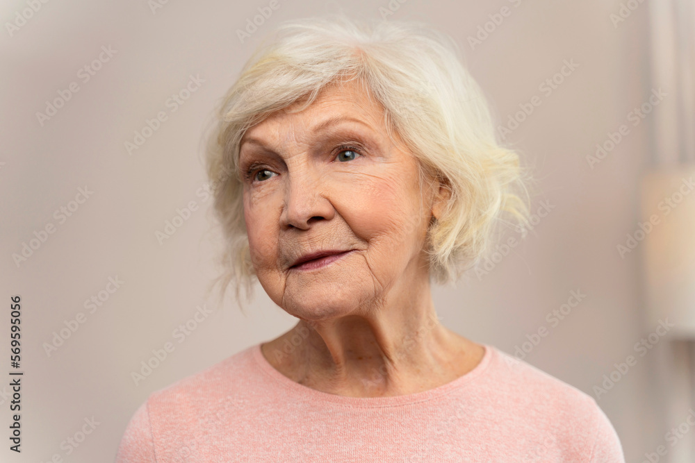 Happy smiling senior woman looking away at home. Old senior woman portrait. Retirement people concept. Stock photo Happy smiling senior woman looking away at home. Old senior woman portrait. Retirement people concept. Stock photo