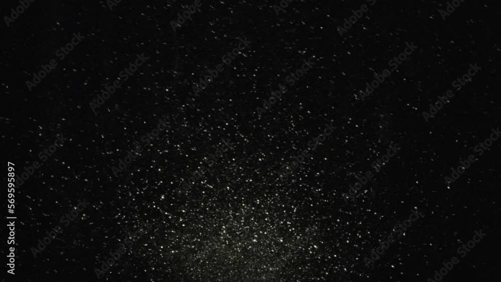 Updraft of Glittering Particles. Sparkling dust particles float in large numbers and rise up in a beam of light on a black background Updraft of Glittering Particles. Sparkling dust particles float in large numbers and rise up in a beam of light on a black background