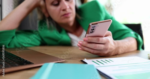Thoughtful woman looking at smartphone screen while thinking about gadget problem