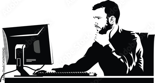 A man in an office looks at computer screen and presses keyboard