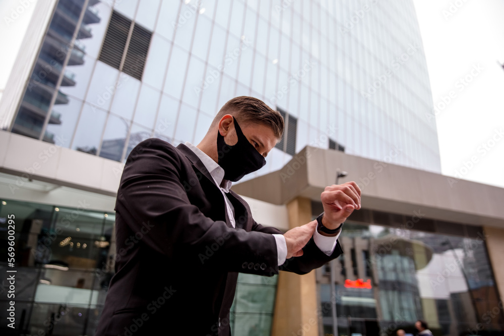 Young businessman in a business center looking at his watch Young businessman in a business center looking at his watch