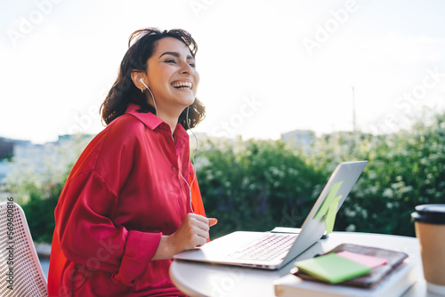 Cheerful woman with laptop at cafe