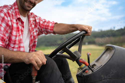 Portrait of young adult Caucasian man farmer sitting in tractor smiling to work. Field farming vehicle. Machine for agriculture.