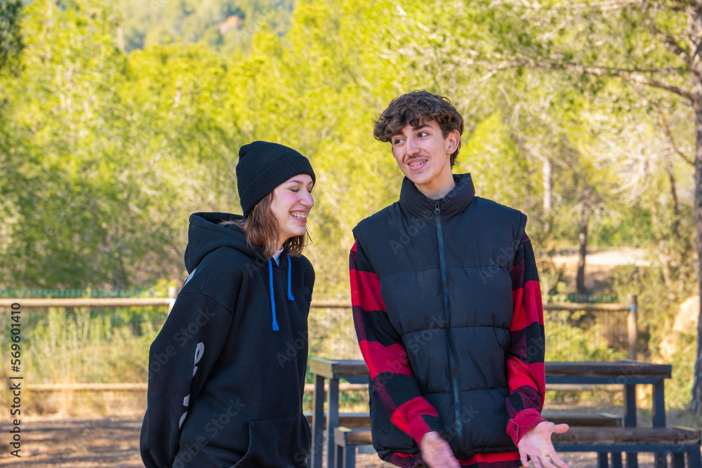 couple of young boy and girl smiling in a park couple of young boy and girl smiling in a park