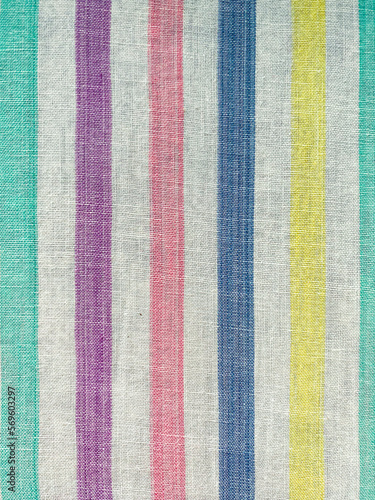 The texture of the fabric. White sheet in multi-colored lines. Cotton, linen, calico. Striped background.