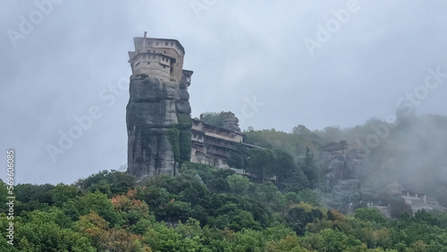 Scenic view of Holy Monastery of St Nicholas Anapafsas surrounded by misty fog on cloudy day, Kalambaka, Meteora, Thessaly, Greece, Europe. Dramatic landscape. Landmark build on unique rock formations