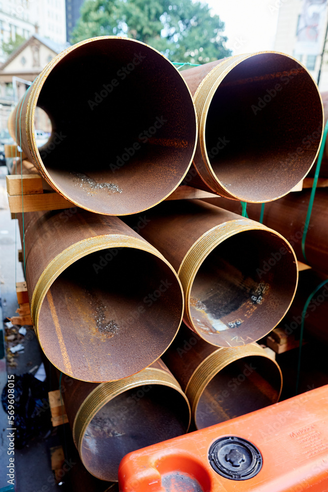 Rusted Pipes with Threaded Ends in Stacks with Green Straps on Construction Site, Vertical View Rusted Pipes with Threaded Ends in Stacks with Green Straps on Construction Site, Vertical View