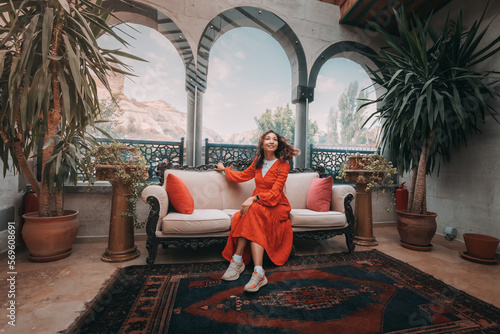 A girl sits comfortably in an authentic Turkish hotel in Cappadocia, surrounded by the region's unique and exotic architecture.