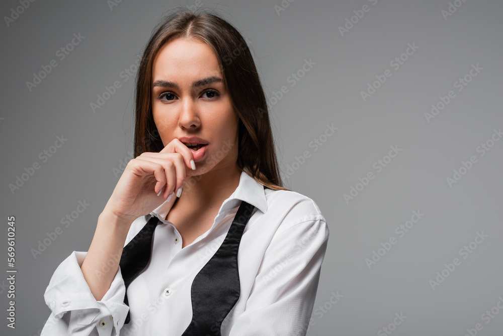portrait of thoughtful woman in white shirt and black tie looking at camera isolated on grey. portrait of thoughtful woman in white shirt and black tie looking at camera isolated on grey.