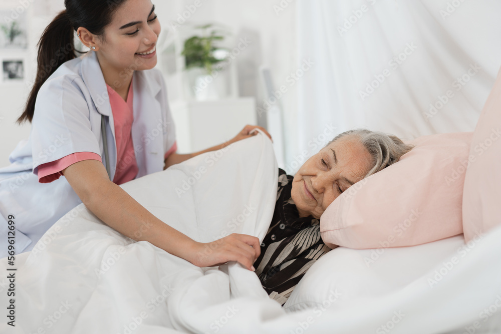Fototapeta premium Woman caucasian doctor take care caucasian older woman of cover her with a blanket in bedroom at home 