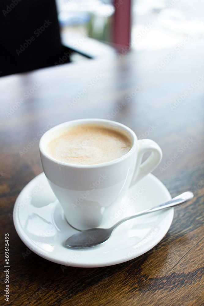 Fototapeta premium Close up white cup of coffee latte on wood table in cafe