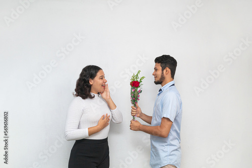 Joven hombre declara su amor ofreciendo flores a hermosa joven mujer photo
