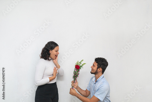 Joven hombre declara su amor ofreciendo flores a hermosa joven mujer photo