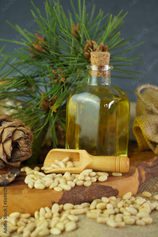 Cedar and spruce essential oil in glass bottle with pine nuts, cones composition Cedar and spruce essential oil in glass bottle with pine nuts, cones composition