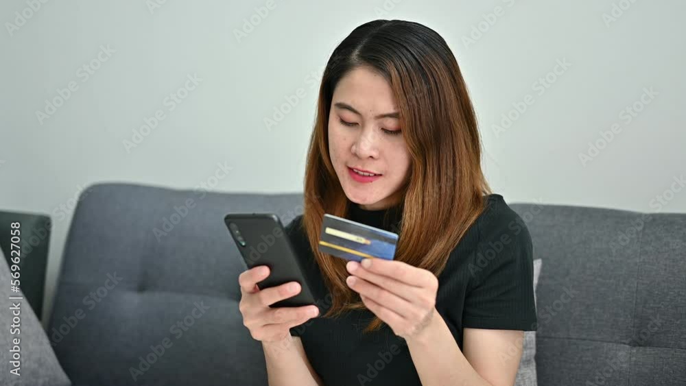 Asian woman while using credit card for shopping online on mobile phone applications. Asian woman while using credit card for shopping online on mobile phone applications.