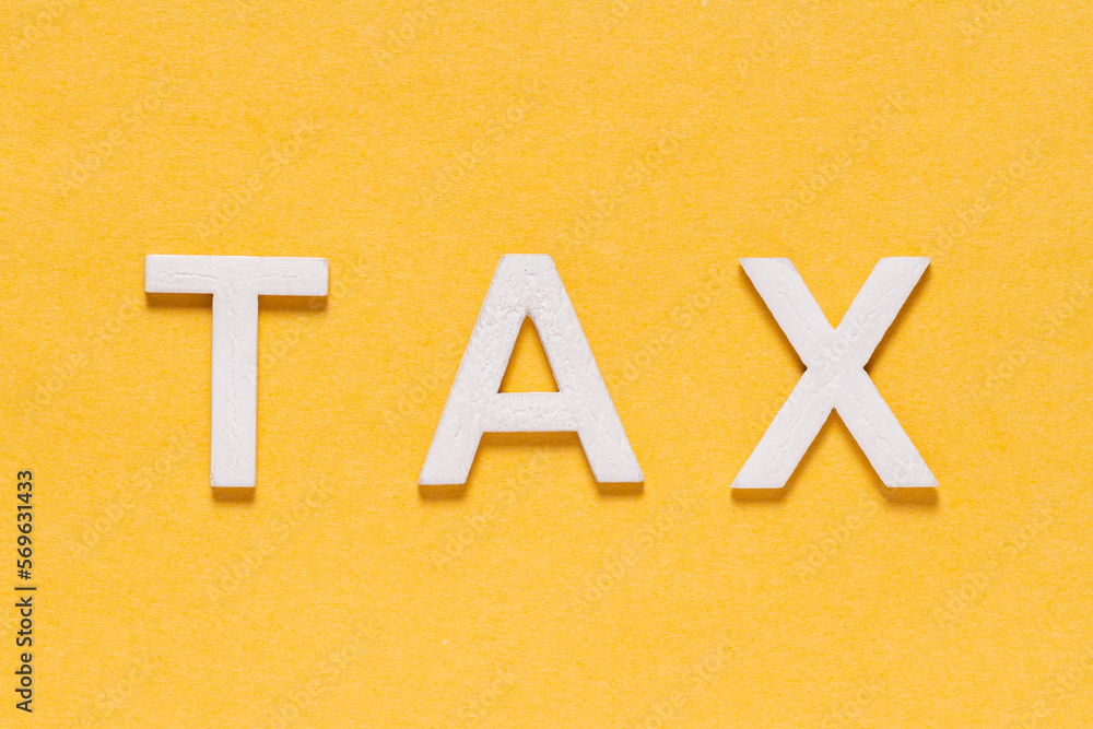 Word TAX, in white letters on yellow background, foreground Word TAX, in white letters on yellow background, foreground