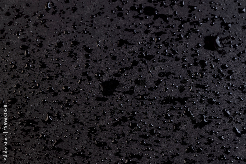 Wet black paper in drops of water Wet black paper in drops of water