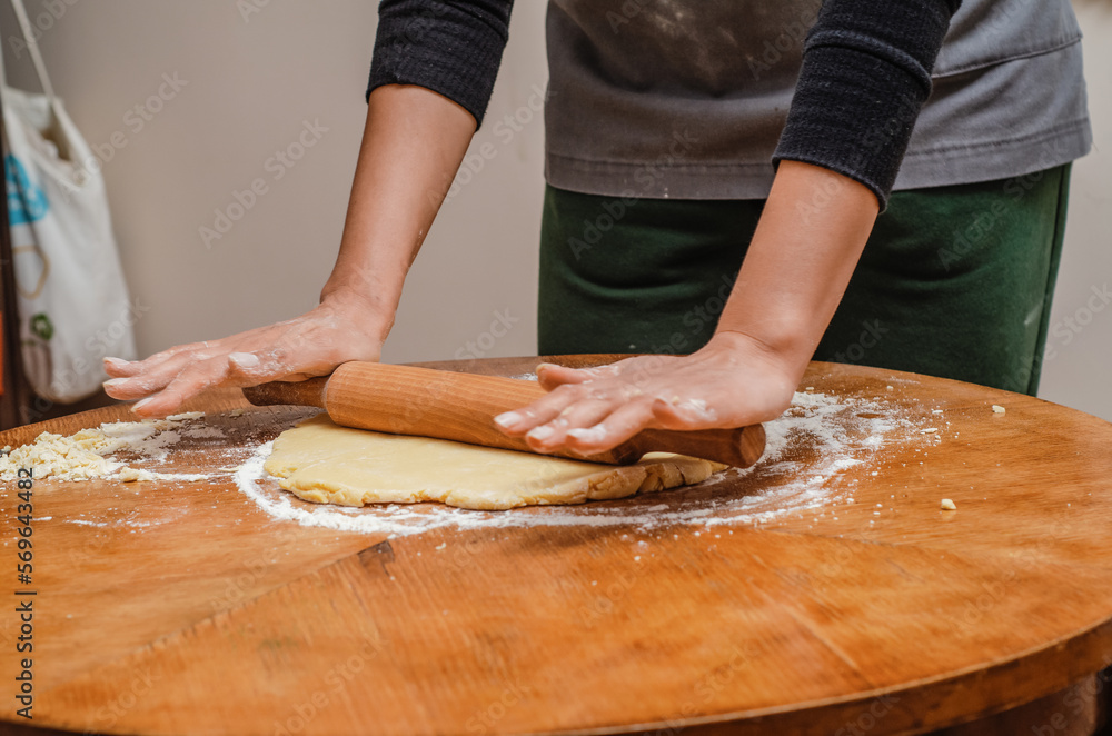 Rolling out cookie dough with a wooden splinter on table Rolling out cookie dough with a wooden splinter on table