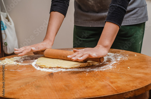Rolling out cookie dough with a wooden splinter on table