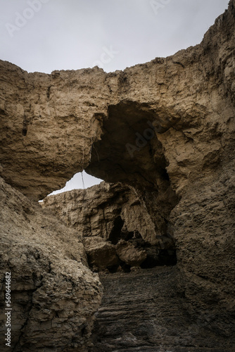 Natural arch made out of clay dirt in washed out dry river bed dirt formation in desert © StockedandLoaded