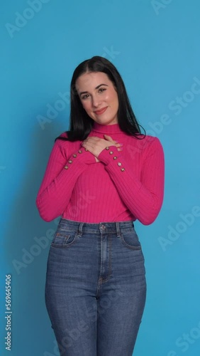 Smiling woman with hands on chest. Vertical Video.