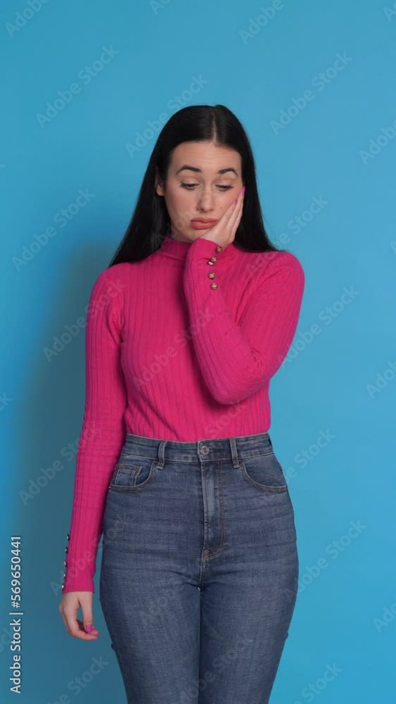 Young woman in sweater looking at camera and looking bored. Vertical Video. Young woman in sweater looking at camera and looking bored. Vertical Video.