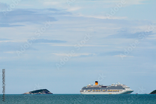 imagem de mar e céu azuis e lindo horizonte com ilha à esquerda e transatlântico à direita photo