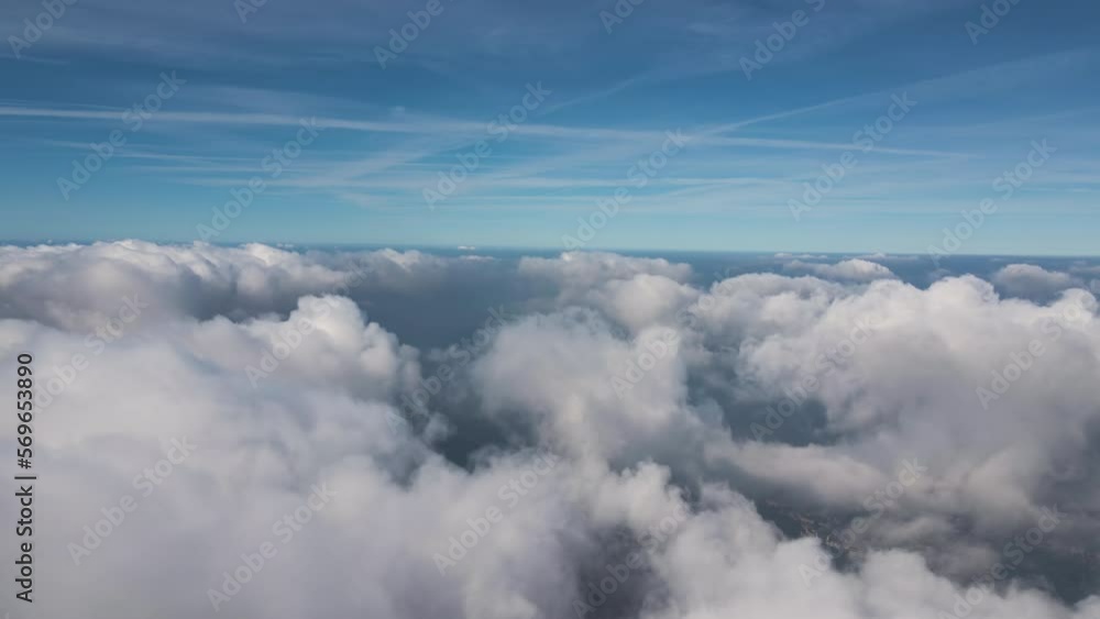 Aerial view from airplane window at high altitude of earth covered with puffy cumulus clouds forming before rainstorm Aerial view from airplane window at high altitude of earth covered with puffy cumulus clouds forming before rainstorm