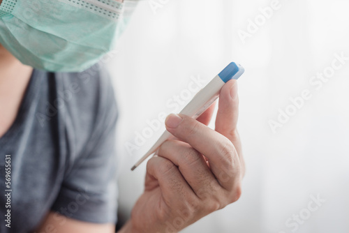 man wearing a mask Taking readings from a thermometer  measuring tools  Medical and home health care concept.