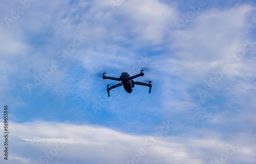 drone flies against the blue sky in the clouds
