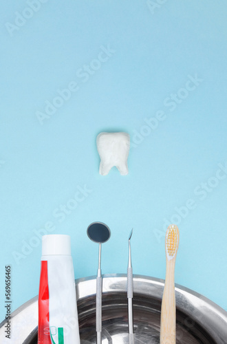 Dentist tools toothbrush, toothpaste and Tooth model on Blue background.. Dental equipment. Dental Care conceptual image background. Dental hygiene. Cure concept. © Alexa Mat
