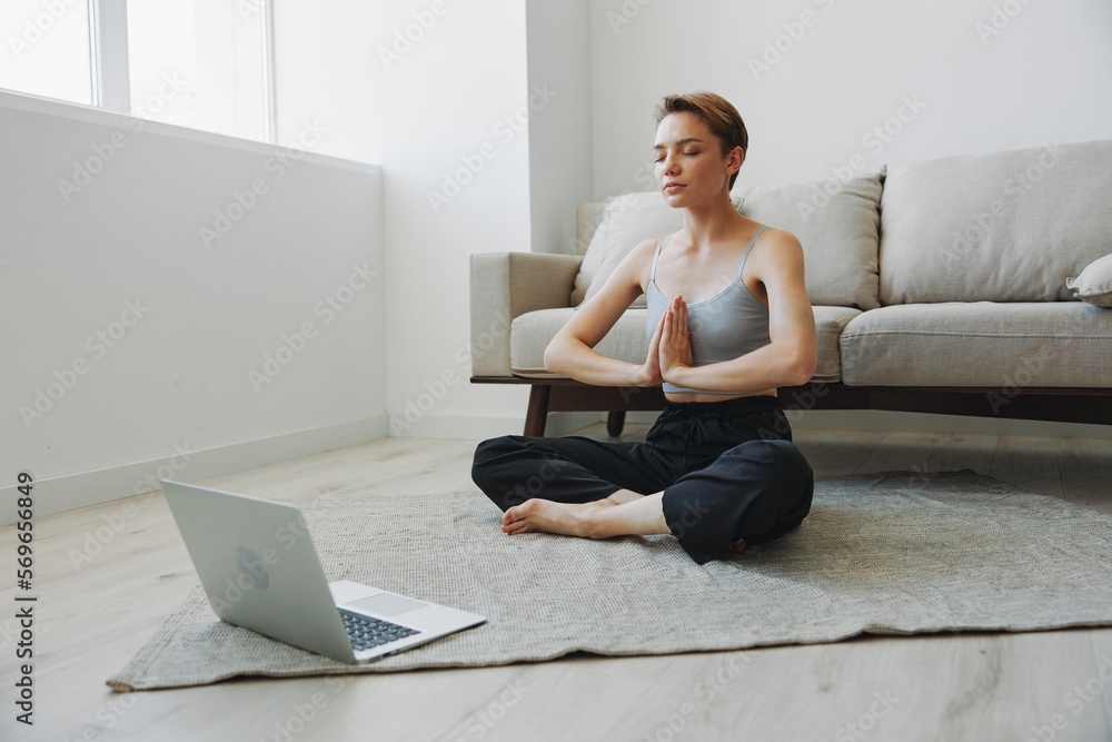 Woman exercising at home by video workout online, meditation and stretching, mental health Woman exercising at home by video workout online, meditation and stretching, mental health