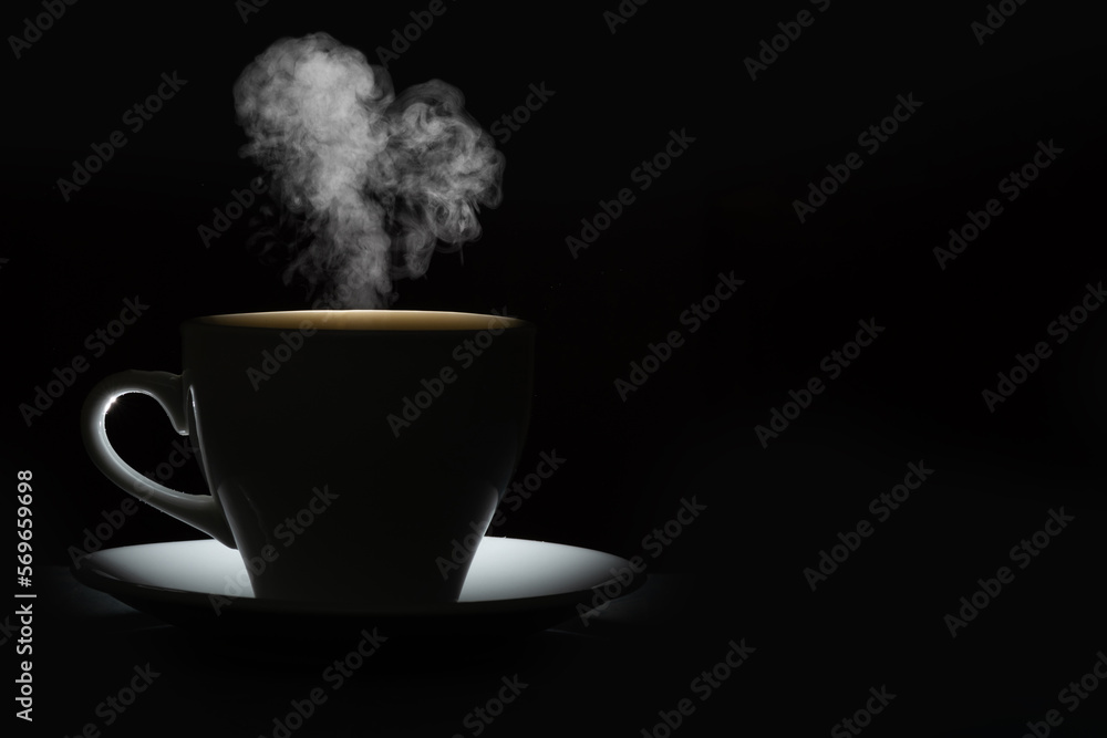 Silhouette of a mug with a warm drink and curly steam in the shape of a heart on a black background. Morning coffee Silhouette of a mug with a warm drink and curly steam in the shape of a heart on a black background. Morning coffee