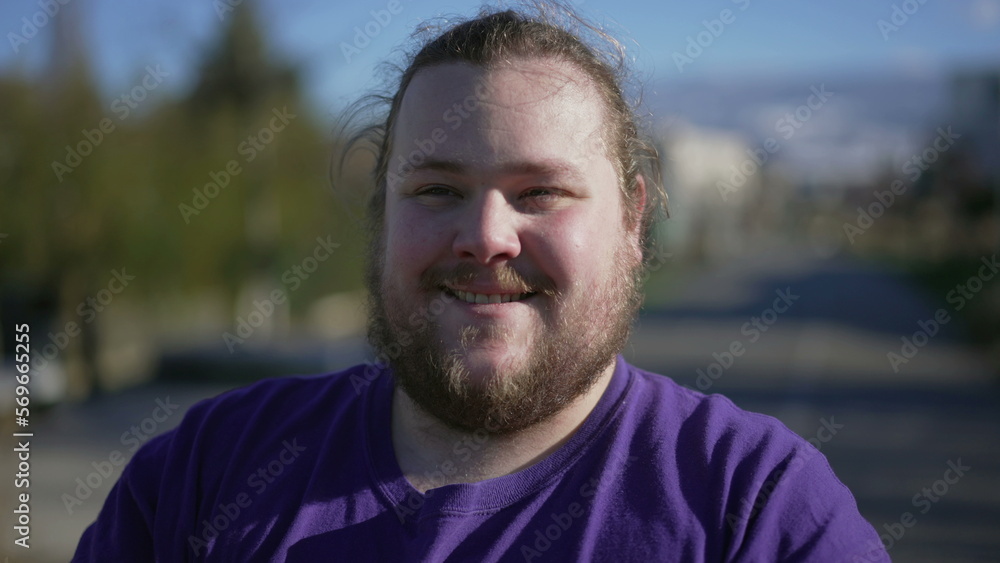Young man standing outside smiling feeling pleased. One casual happy positive overweight male person. Tracking shot Young man standing outside smiling feeling pleased. One casual happy positive overweight male person. Tracking shot