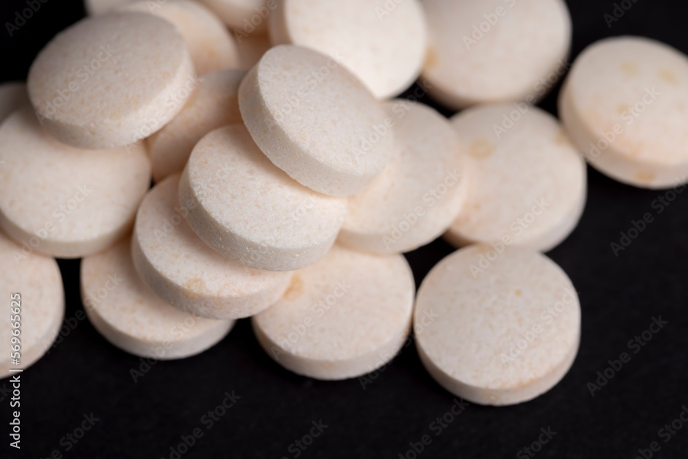 White and yellow medical medicines on a black background White and yellow medical medicines on a black background