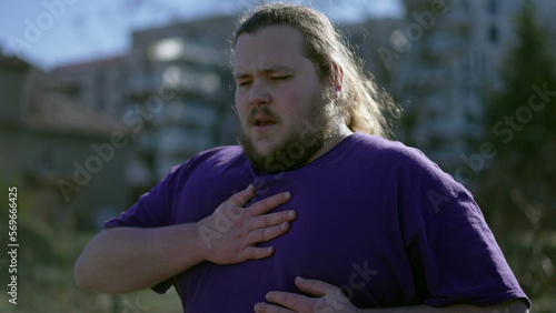 Φωτογραφία One young overweight man having chest pains standing outdoors