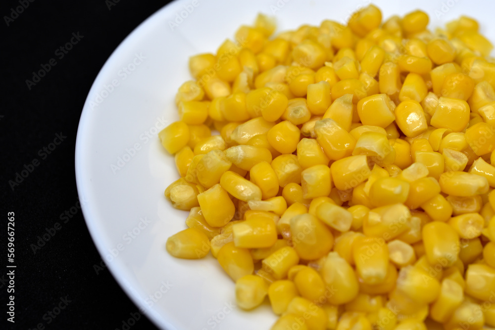 Fresh canned corn on a white plate. Corn salad. Yellow corn kernels. Fresh canned corn on a white plate. Corn salad. Yellow corn kernels.