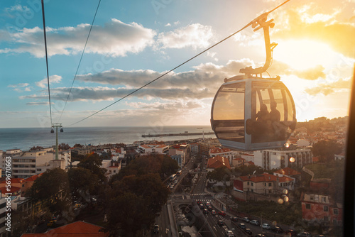 Beautiful city of Funchal with houses, funicular cable car, ocean and amazing sunset. Journey to Madeira Island. Travel
