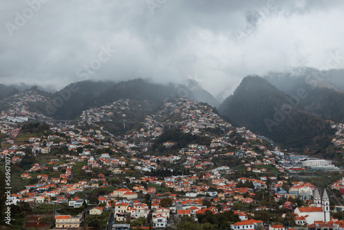 Beautiful mountain landscape with clouds and houses on the island of Madeira