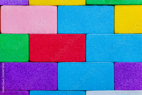 Background, texture, wall, from children's colored, multi-colored blocks, bricks on the playground for children's games. Closeup photo, concept of childhood and construction.