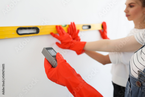 Принти на полотні Laser rangefinder or laser tape measure in a female hand